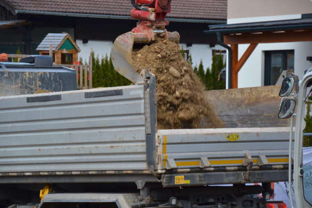 LKW beim Beladen mit Aushubmaterial durch Bagger