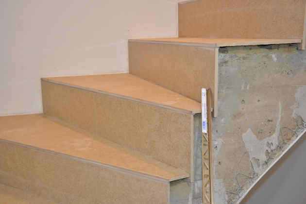 Gewendelte Treppe mit Fliesenbelag auf Tritt- und Setzstufen