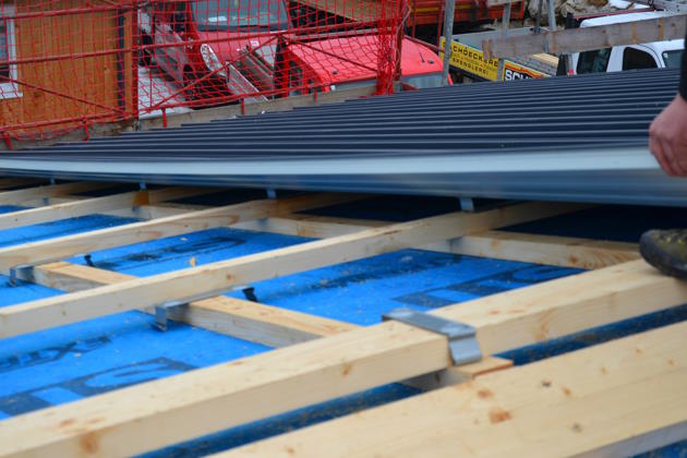 Verlegung von Blechbahnen auf Holzunterkonstruktion eines Satteldachs