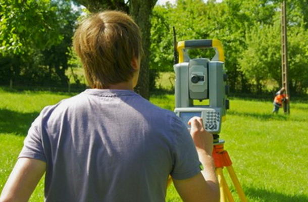 Geometer beim vermessen mit Theodolit