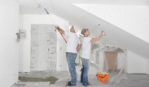 Zwei Maler beim Streichen der Dachschräge und Zimmerdecke