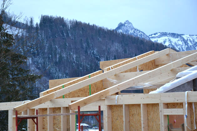 Holzrahmenbau mit Dachsparren und Schnee auf Mauerbänken