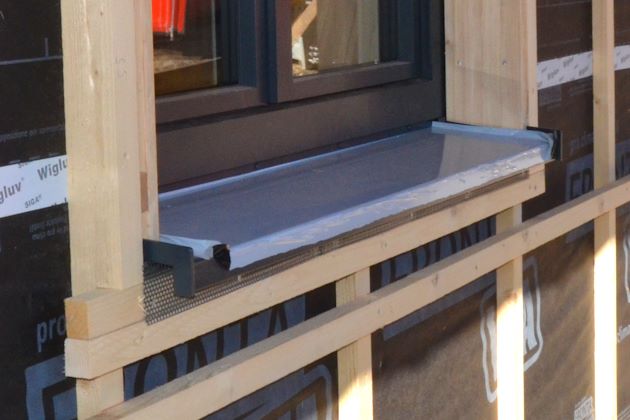 Nicht schlagregendichte Außenfensterbank aus beschichtetem Aluminium mit seitlichen Abdeckkappen bei Holzbau