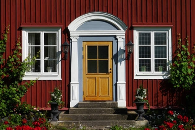 Haustür in Haus mit roter Holzfassade