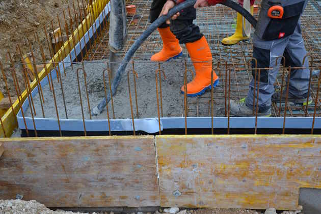 Arbeiter beim Betonieren einer Bodenplatte