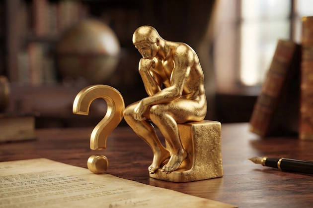 3D-Gold-Piktogramm von Rodins ‚Denker‘, der nachdenklich auf ein großes goldenes Fragezeichen auf einem Schreibtisch mit Füllfederhalter und Buch blickt.